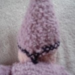 knitted doll - sewing hat on